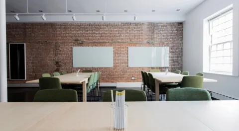 Una sala riunioni vuota con il tavolo lungo e le lavagne bianche: il posto dove si decide a chi affidare il lavoro