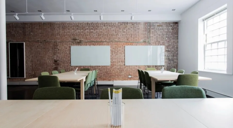 Una sala riunioni vuota con il tavolo lungo e le lavagne bianche: il posto dove si decide a chi affidare il lavoro