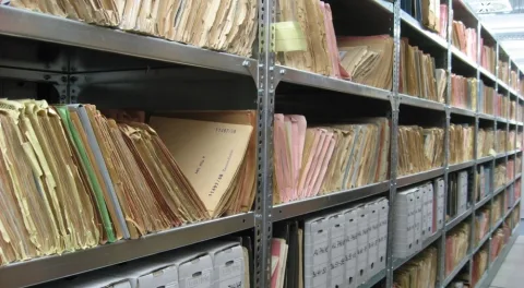Scaffali pieni di faldoni di carta in un archivio: il lavoro che un software gestionale toglie di mezzo
